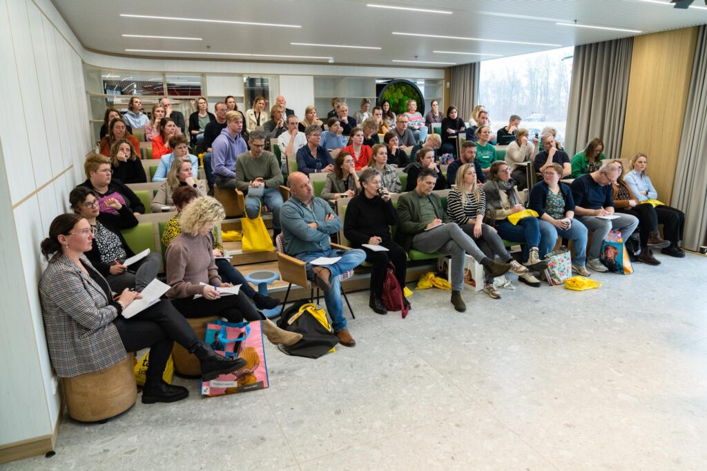 Grote groep in de zaal luisterend naar de eerste presentatie van Heutink tijdens de onderwijsmarkt