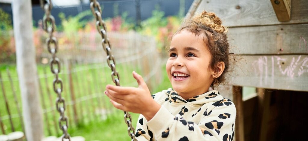 Kleine meisje met krullend haar op een schommel|Afbeelding van handige lestips voor basisonderwijs