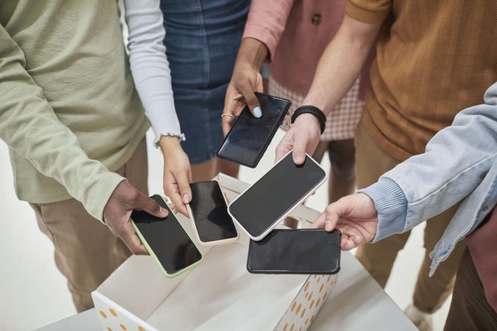 Closeup van studenten die hun mobiel in een mand leggen voordat ze de klas ingaan op school.