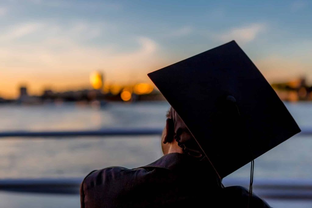 Afgestudeerde student met cap op het hoofd kijkende naar de horizon|Vrouw met kompas in de hand