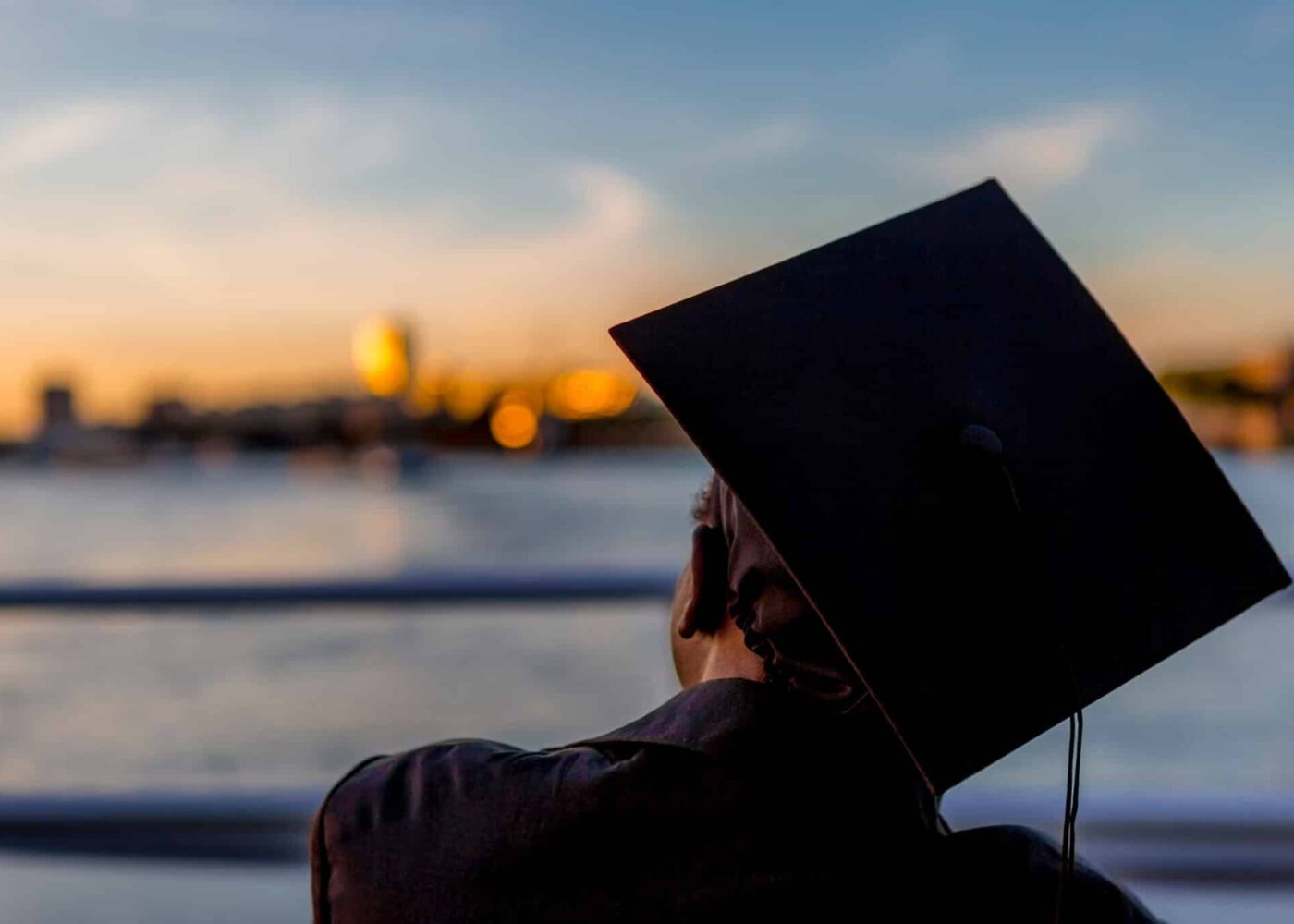 Afgestudeerde student met cap op het hoofd kijkende naar de horizon|Vrouw met kompas in de hand