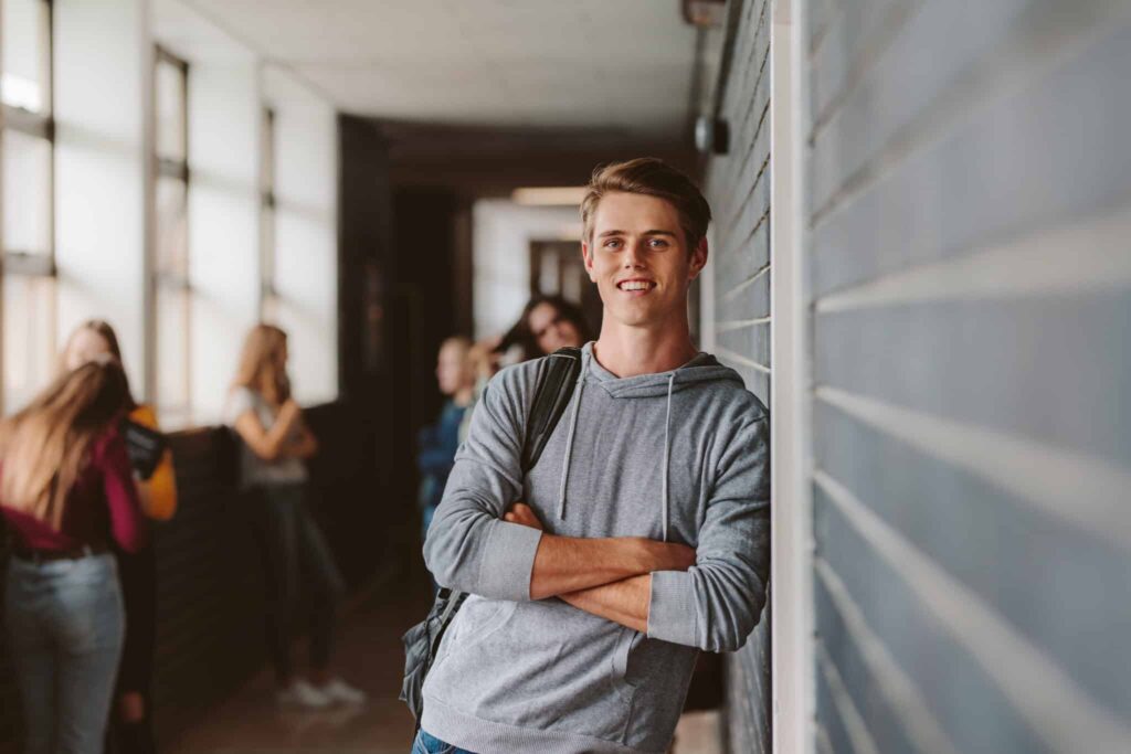 Student leunt in de gang van de school tegen de muur